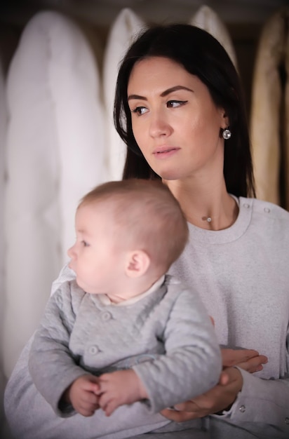 Junge glückliche Familie auf dem Einkaufen Junge Mutter, die ein Baby hält Porträt