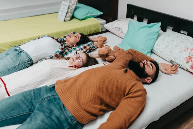 Foto junge glückliche familie kauft neues bett und matratze in einem großen möbelhaus