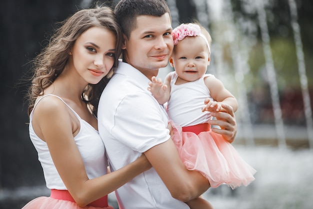 Foto junge glückliche familie nahe dem brunnen