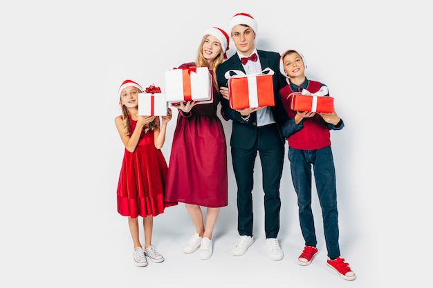 Junge glückliche Familienweihnachten mit den Kindern in den Weihnachtsmützen