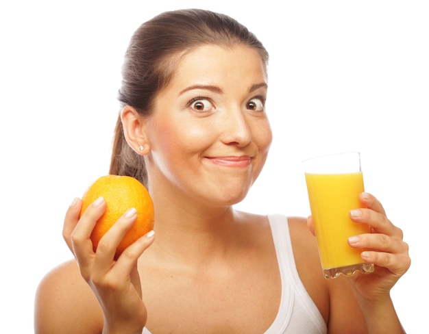 Junge glückliche Frau, die Orangensaft trinkt