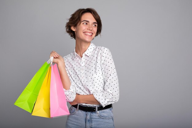 Junge glückliche Frau mit kurzen Haaren hält Einkaufspapiertüten in den Händen Schwarzer Freitag Verbraucher Käufer Verkauf Geschäft Zahlung Online-Kauf Rabatt Kauf Mall E-Commerce Bestellangebot