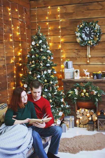 Junge glückliche lustige Familie nahe Weihnachtsbaum