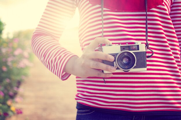 Junge glückliche Mädchen mit Fotografie Blumen in Urlaub Reise (Vintage Farbton)