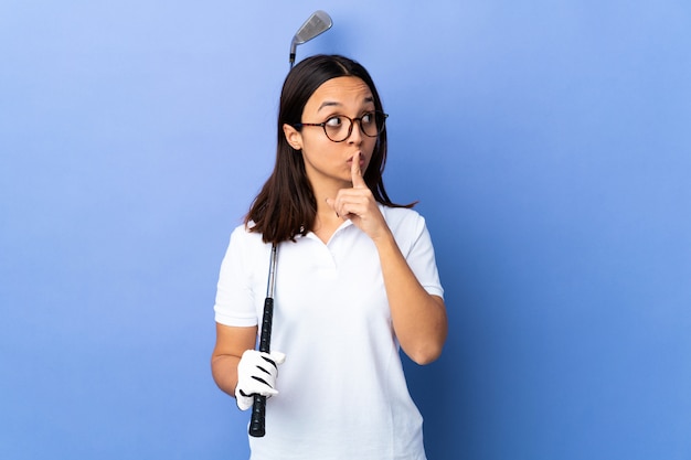 Junge Golferfrau über lokalisiertem buntem Hintergrund, der ein Zeichen der Stille Geste zeigt Finger in den Mund setzen