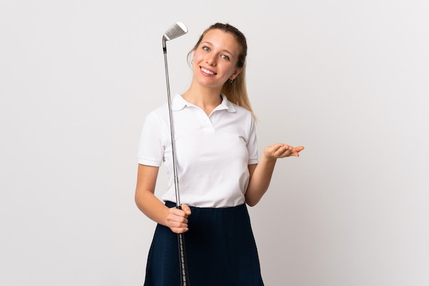 Junge Golferin über isolierter weißer Wand, die Hände zur Seite für Einladung zum Kommen ausdehnt