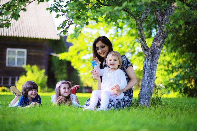 Junge große Familie auf einem Sommermorgenspaziergang. Schöne Mutter mit Kindern spielt im Park.