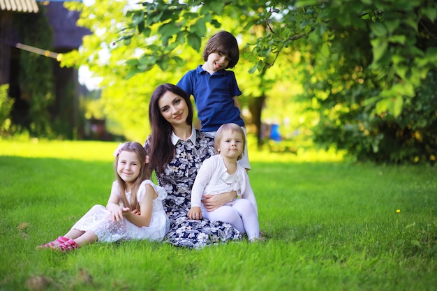 Junge große Familie auf einem Sommermorgenspaziergang. Schöne Mutter mit Kindern spielt im Park.