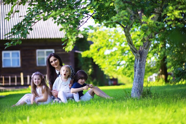 Junge große Familie auf einem Sommermorgenspaziergang. Schöne Mutter mit Kindern spielt im Park.