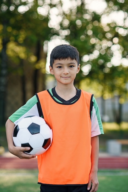 Junge hält Ball nach dem Training in einer Hand