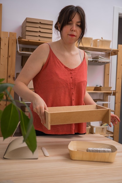 junge Handwerkerin, die in ihrer Werkstatt für Bio-Produkte arbeitet