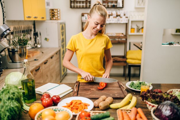 Junge Hausfrau, die auf der Küche kocht, Öko-Nahrung