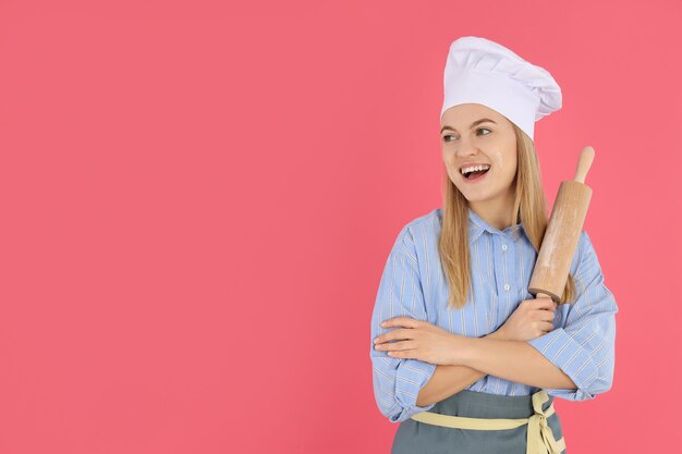 Junge Hausfrau oder Koch auf rosa Hintergrund