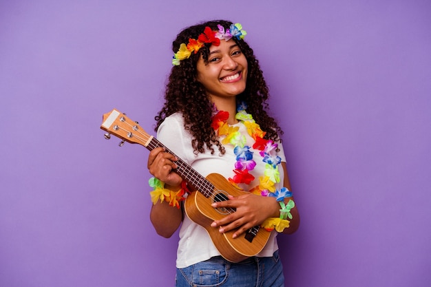 Junge hawaiianische Frau spielt Ukelele isoliert auf lila Hintergrund