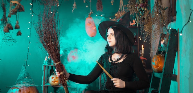 Junge Hexe zaubert zu Halloween zu Hause