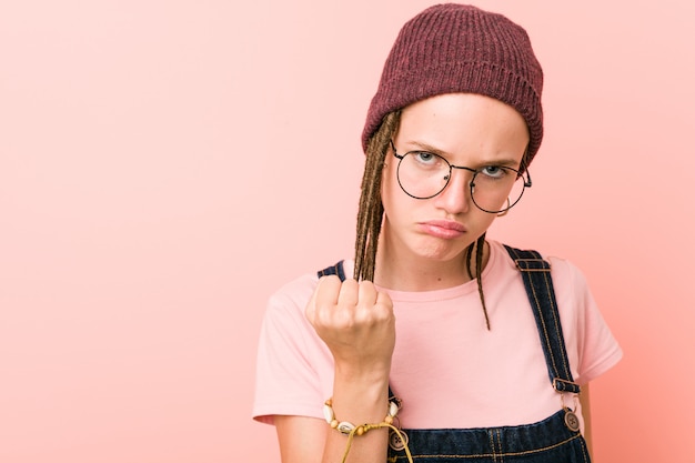 Junge Hippie-Frau, die Faust zur Kamera, aggressiver Gesichtsausdruck zeigt.