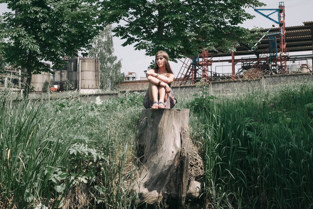 Junge Hippiefrau, die nahe dem Teich sitzt. das Konzept der Einheit mit der Natur