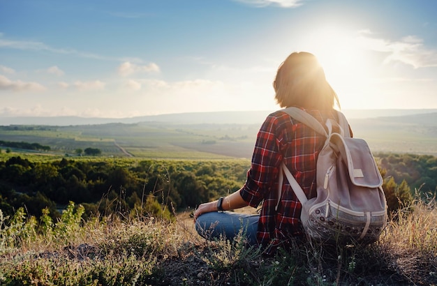 Junge Hipster-Mädchen genießen den Sonnenuntergang am Aussichtspunkt Reisefrau mit Rucksack