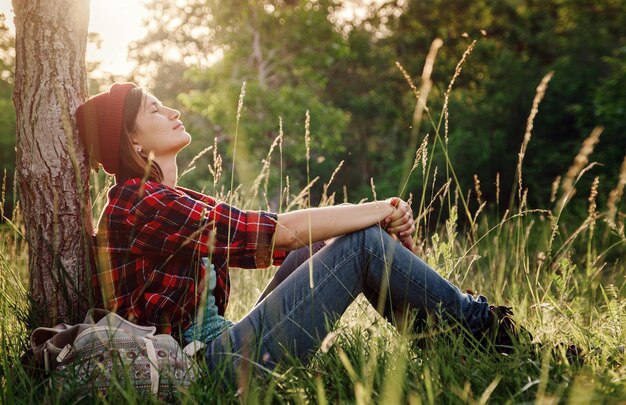 Foto junge hipster-mädchen genießen sonnenuntergang reisefrau mit rucksack