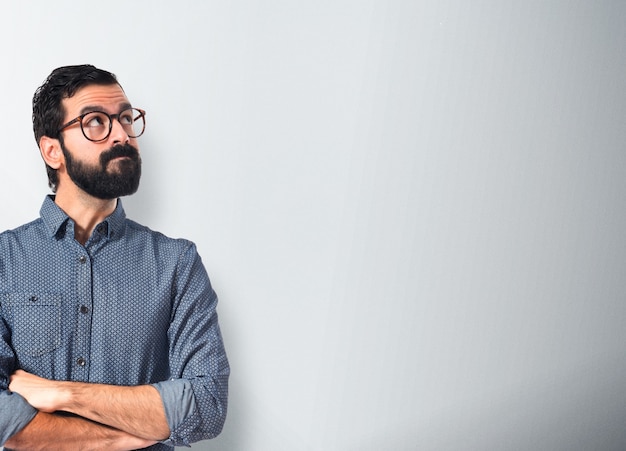 Junge Hipster Mann Denken über weißem Hintergrund