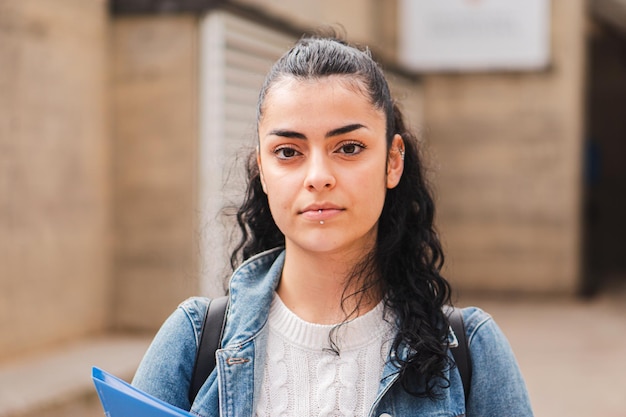 Junge hispanische ernste Mädchen Brunettestudent, der Kamera ernst betrachtet Juvenile jugendlich Dame, die steht