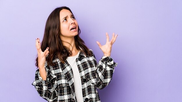 Junge hispanische Frau der gemischten Rasse isoliert, schreit zum Himmel, schaut auf, frustriert.