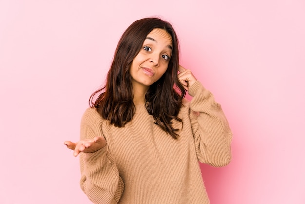 Junge hispanische Frau der gemischten Rasse isolierte das Halten und Zeigen eines Produkts zur Hand.