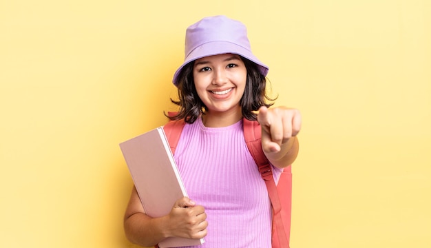 Junge hispanische Frau, die auf die Kamera zeigt und Sie auswählt. zurück zum schulkonzept