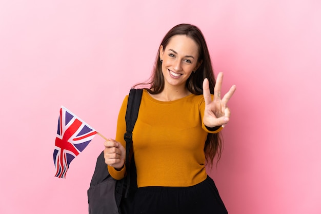 Junge hispanische Frau, die eine britische Flagge glücklich hält und drei mit den Fingern zählt