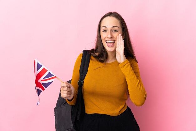 Junge hispanische Frau, die eine britische Flagge hält, die mit offenem Mund schreit