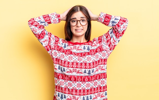 Foto junge hispanische frau, die sich gestresst, ängstlich oder ängstlich fühlt, mit den händen auf dem kopf. weihnachten und neujahr konzept