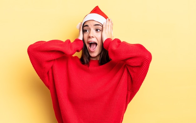 Junge hispanische Frau, die sich glücklich, aufgeregt und überrascht fühlt. Weihnachten und Neujahr Konzept