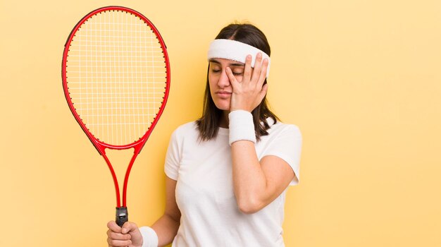 Junge hispanische Frau, die sich nach einem ermüdenden Tenniskonzept gelangweilt, frustriert und schläfrig fühlt