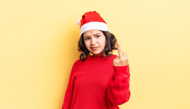 Junge hispanische Frau, die sich wütend, verärgert, rebellisch und aggressiv fühlt. Weihnachtskonzept