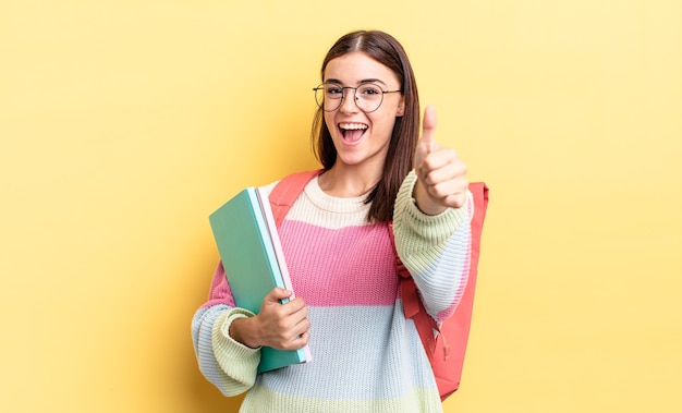 Junge hispanische Frau, die stolz ist und positiv mit Daumen nach oben lächelt. studentisches Konzept