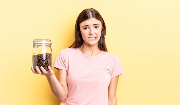 Foto junge hispanische frau, die verwirrt und verwirrt aussieht. kaffeebohnen-konzept