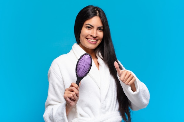 Junge hispanische Frau mit einer Haarbürste.