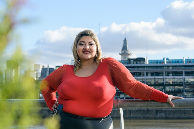 Foto junge hispanische latina-frau in übergröße, die im freien steht und in die kamera schaut