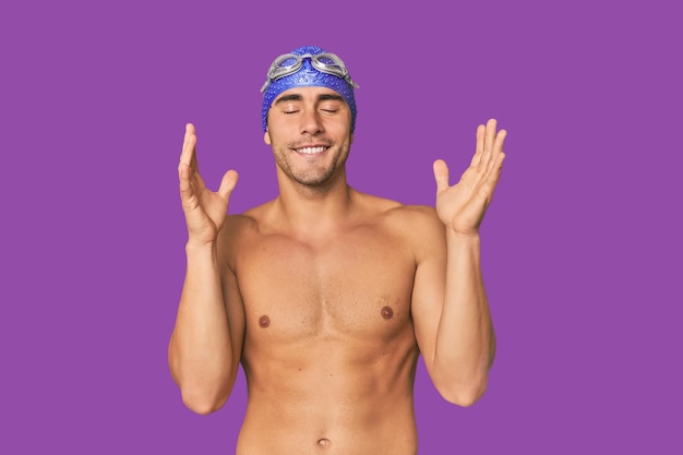 Junge hispanische Mann mit Schwimmbekleidung fröhlich viel lachen Glück Konzept