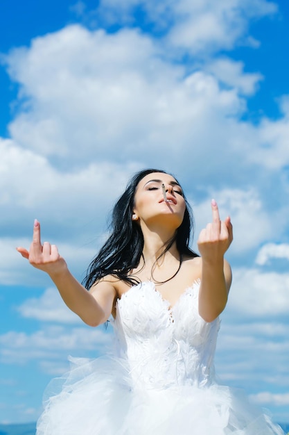 Junge Hochzeit sexy Mädchen Frau mit brünetten Haaren und hübschem Gesicht im weißen Brautkleid Mitte zeigt