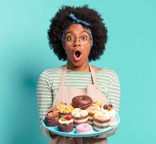 Junge hübsche Afro-Bäckerin mit Kuchen