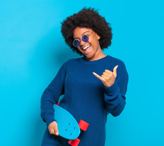 Junge hübsche Afro-Frau mit einem Skateboard