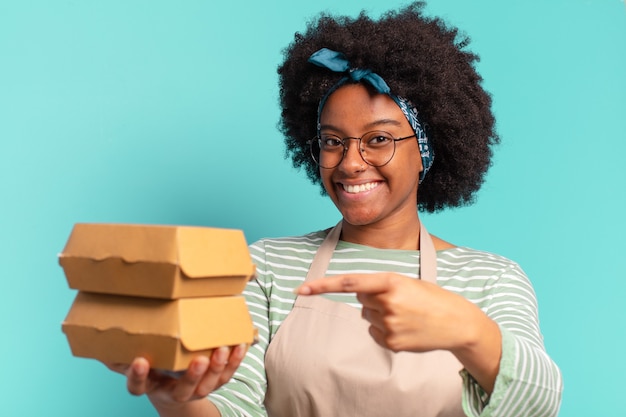 Junge hübsche Afro liefern Frau mit einem Mitnehmen Burgerboxen