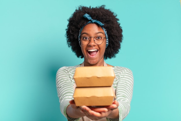 Junge hübsche Afro liefern Frau mit einem Mitnehmen Burgerboxen