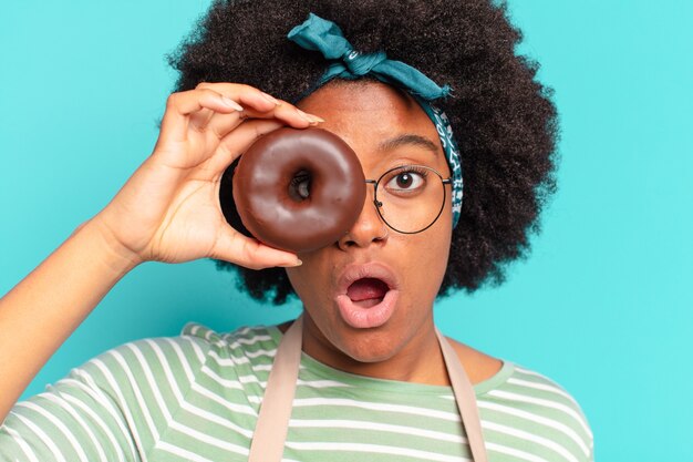 Foto junge hübsche afrofrau mit donut