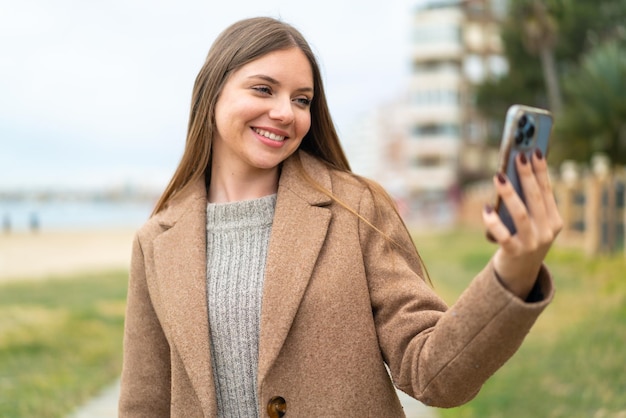 Junge hübsche blonde Frau, die ein Selfie mit Handy macht