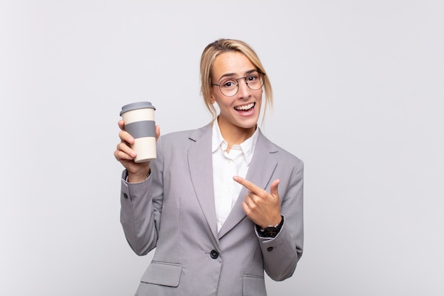 Junge hübsche blonde Frau mit einem Kaffee zum Mitnehmen