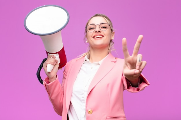 Junge hübsche blonde Frau mit einem Megaphon