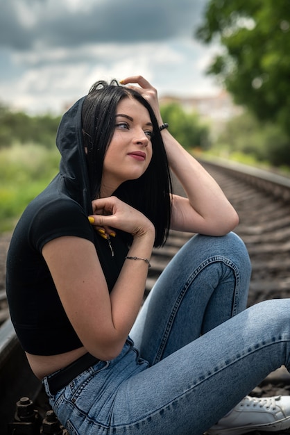 Junge hübsche Dame genießt die Sommerzeit auf der Bahnstrecke in der Natur