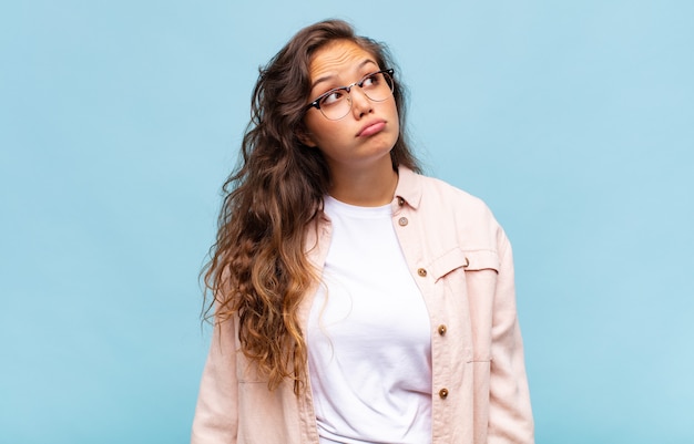 junge hübsche Frau auf blauem Hintergrund mit Brille